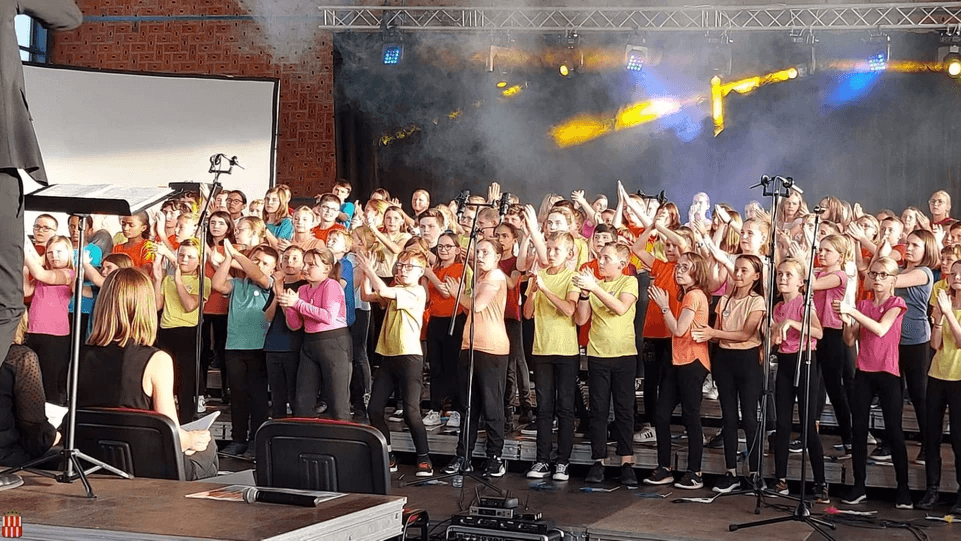 Chorale d'enfants sur scène dirigée lors d'un projet pédagogique